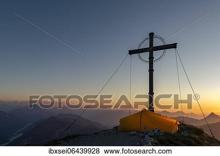 Sunset over Lechtal mountains, in the foreground summit cross of the Geierkopf with tent, Reutte, Ammergau Alps, Tyrol, Austria, Europe View Large Photo Image Stock Photo - Sunset over Lechtal mountains, in the foreground summit cross of the Geierkopf with tent, Reutte, Ammergau Alps, Tyrol, Austria, Europe. Fotosearch