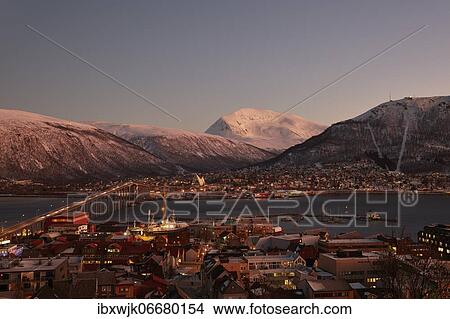 View of the harbour and the city with Tromsø Bridge and Ice Sea Cathedral, behind Tromsdaltinden and Storsteinen, twilight in the polar night, Tromsø, Troms, Norway, Europe View Large Photo Image Picture - View of the harbour and the city with Tromsø Bridge and Ice Sea Cathedral, behind Tromsdaltinden and Storsteinen, twilight in the polar night, Tromsø, Troms, Norway, Europe. Fotosearch