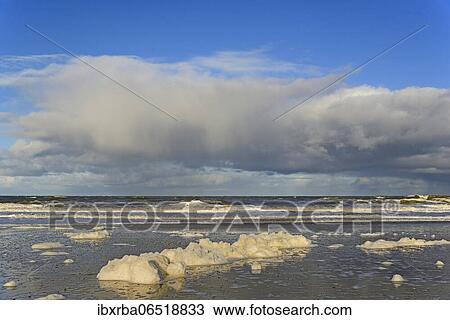 Waves on a sandy beach with foam formation, blue sky with deep swelling clouds (cumulus) over the North Sea, Norderney, East Frisian Islands, Lower Saxony, Germany, Europe View Large Photo Image Stock Image - Waves on a sandy beach with foam formation, blue sky with deep swelling clouds (cumulus) over the North Sea, Norderney, East Frisian Islands, Lower Saxony, Germany, Europe. Fotosearch