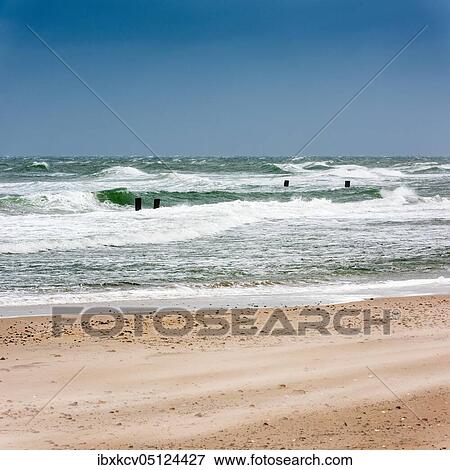 Stock Photo - Winter storm at the Baltic Sea, groyne in the surf, sand is blown over the beach, near Graal-Müritz, Mecklenburg-Western Pomerania, Germany, Europe. Fotosearch