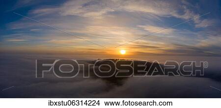 Wooded hill rises from cloud cover at sunrise, Aargau, Switzerland, Europe View Large Photo Image Picture - Wooded hill rises from cloud cover at sunrise, Aargau, Switzerland, Europe. Fotosearch