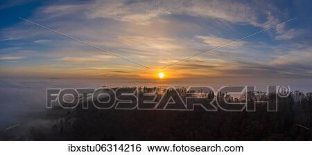Wooded hill rises from cloud cover at sunrise, Aargau, Switzerland, Europe View Large Photo Image Stock Photograph - Wooded hill rises from cloud cover at sunrise, Aargau, Switzerland, Europe. Fotosearch