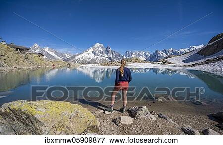 Young woman in front of mountain panorama, reflection in Lac Blanc, mountain peaks, Grandes Jorasses and Mont Blanc massif, Chamonix-Mont-Blanc, Haute-Savoie, France, Europe View Large Photo Image Stock Photo - Young woman in front of mountain panorama, reflection in Lac Blanc, mountain peaks, Grandes Jorasses and Mont Blanc massif, Chamonix-Mont-Blanc, Haute-Savoie, France, Europe. Fotosearch