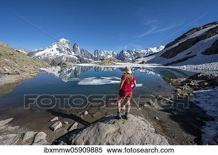 Young woman in front of mountain panorama, reflection in Lac Blanc, mountain peaks, Grandes Jorasses and Mont Blanc massif, Chamonix-Mont-Blanc, Haute-Savoie, France, Europe View Large Photo Image Stock Photography - Young woman in front of mountain panorama, reflection in Lac Blanc, mountain peaks, Grandes Jorasses and Mont Blanc massif, Chamonix-Mont-Blanc, Haute-Savoie, France, Europe. Fotosearch
