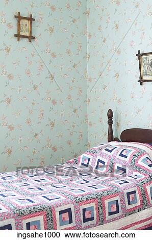Bedroom with patterned wallpaper and a quilt on the bed View Large Photo Image Stock Image - Bedroom with patterned wallpaper and a quilt on the bed. Fotosearch