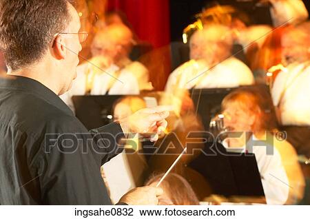 Blur of conductor in front of orchestra View Large Photo Image Stock Image - Blur of conductor in front of orchestra. Fotosearch