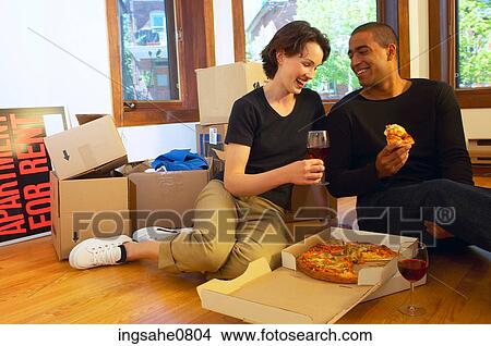 Couple having pizza and red wine in empty apartment View Large Photo Image Picture - Couple having pizza and red wine in empty apartment. Fotosearch