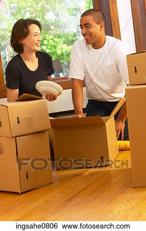 Couple packing dishes in empty apartment View Large Photo Image Stock Photograph - Couple packing dishes in empty apartment. Fotosearch