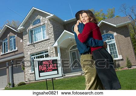 Embracing young couple who have just bought a house 1 View Large Photo Image Stock Image - Embracing young couple who have just bought a house 1. Fotosearch