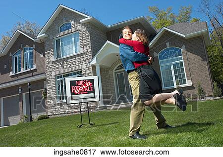 Embracing young couple who have just bought a house View Large Photo Image Stock Photo - Embracing young couple who have just bought a house. Fotosearch