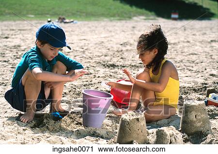Stock Image - girl and boy playing in sand 0002. Fotosearch