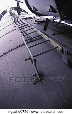 Ladder on side of metal factory holding tower View Large Photo Image Stock Photograph - Ladder on side of metal factory holding tower. Fotosearch