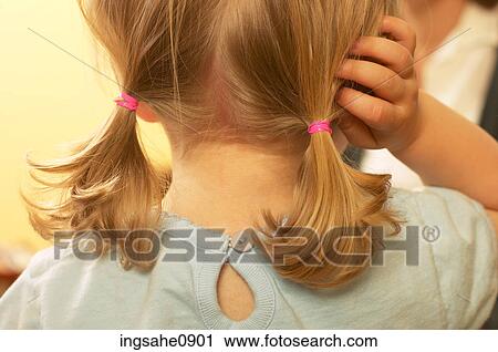 Stock Image - Little girl wearing ponytails. Fotosearch
