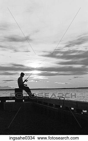 Man fishing off pier at sunset View Large Photo Image Picture - Man fishing off pier at sunset . Fotosearch