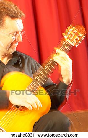 Man playing acoustic guitar on stage View Large Photo Image Stock Image - Man playing acoustic guitar on stage . Fotosearch