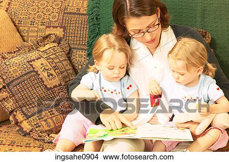 Mother reading story with twin little girls 1 View Large Photo Image Picture - Mother reading story with twin little girls 1. Fotosearch