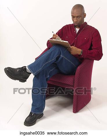 Seated man reading clipboard 1 View Large Photo Image Stock Photography - Seated man reading clipboard 1. Fotosearch