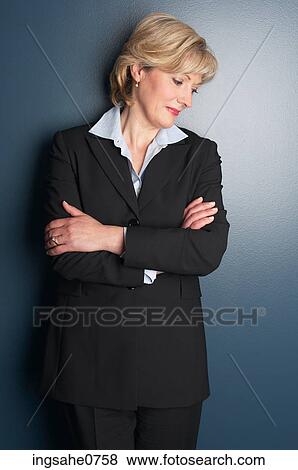 Smiling businesswoman leaning against wall View Large Photo Image Stock Photo - Smiling businesswoman leaning against wall. Fotosearch