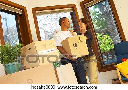 Smiling couple moving boxes out of empty apartment View Large Photo Image Stock Photo - Smiling couple moving boxes out of empty apartment. Fotosearch