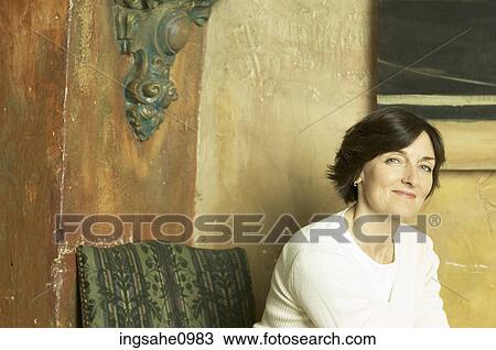 Smiling woman sitting against stone wall 1 View Large Photo Image Stock Image - Smiling woman sitting against stone wall 1. Fotosearch