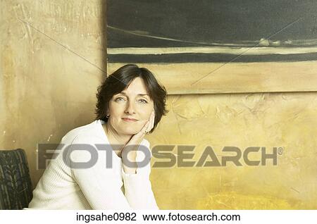 Smiling woman sitting against stone wall View Large Photo Image Stock Image - Smiling woman sitting against stone wall. Fotosearch