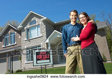 Smiling young couple in front of their new home 5 View Large Photo Image Picture - Smiling young couple in front of their new home 5. Fotosearch