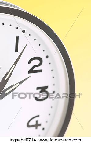 Picture - Stainless steel clock on yellow surface 1. Fotosearch