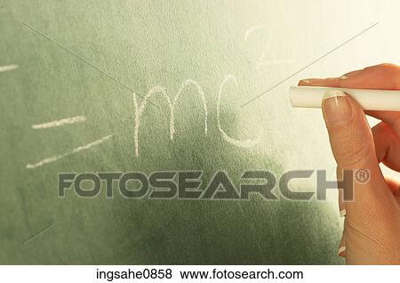 Stock Photo - Teacher writing physics equation on chalkboard 1. Fotosearch
