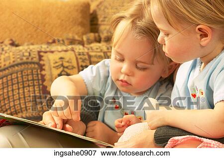 Twin little girls reading a story View Large Photo Image Stock Photo - Twin little girls reading a story. Fotosearch