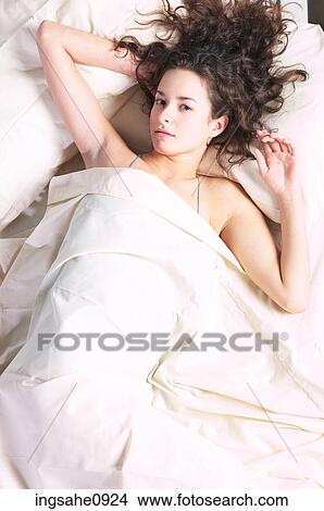 Woman lying in white bed sheets 1 View Large Photo Image Picture - Woman lying in white bed sheets 1. Fotosearch
