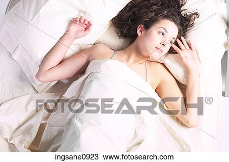 Woman lying in white bed sheets View Large Photo Image Stock Image - Woman lying in white bed sheets. Fotosearch