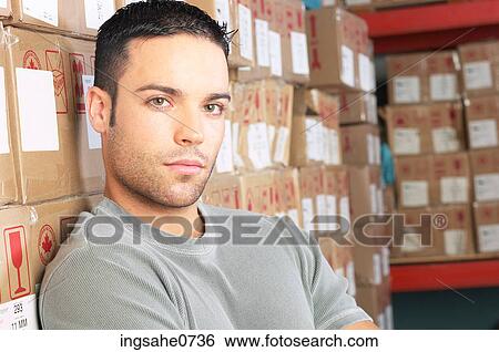 Workman leaning against cardboard boxes on shelves 1 View Large Photo Image Stock Photograph - Workman leaning against cardboard boxes on shelves 1. Fotosearch