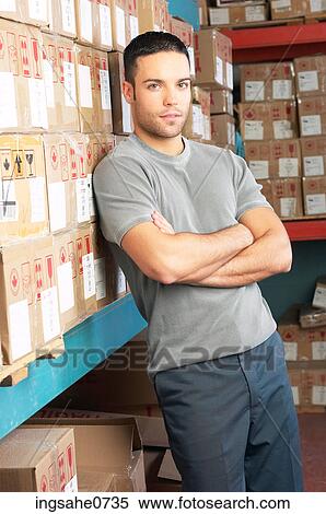 Workman leaning against cardboard boxes on shelves View Large Photo Image Stock Photography - Workman leaning against cardboard boxes on shelves. Fotosearch