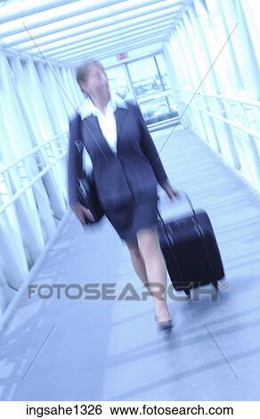Stock Photograph - Blur of businesswoman pulling suitcase . Fotosearch