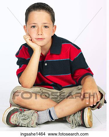 Picture - boy sitting on ground . Fotosearch