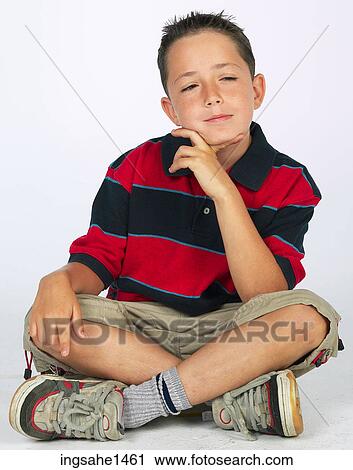Stock Image - boy sitting on ground . Fotosearch