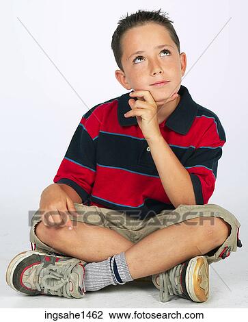Stock Image - boy sitting on ground . Fotosearch