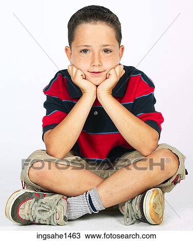 Stock Image - boy sitting on ground . Fotosearch