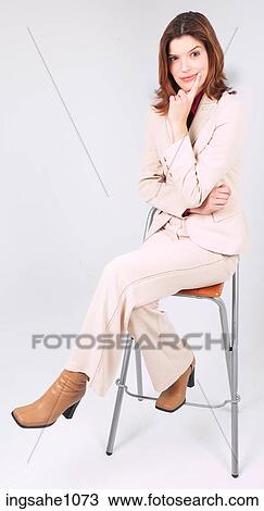 Stock Image - Businesswoman sitting on stool smiling a84. Fotosearch