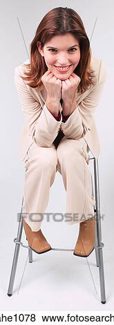 Stock Photo - Businesswoman sitting on stool with chin in hands a81. Fotosearch