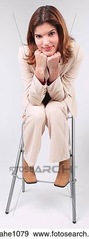 Businesswoman sitting on stool with chin in hands a82 View Large Photo Image Stock Photo - Businesswoman sitting on stool with chin in hands a82. Fotosearch