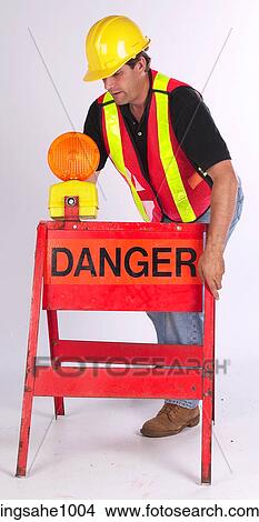 Construction worker setting up danger sign View Large Photo Image Picture - Construction worker setting up danger sign. Fotosearch