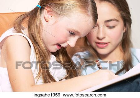 Stock Photo - Girl coloring picture on sofa BE. Fotosearch