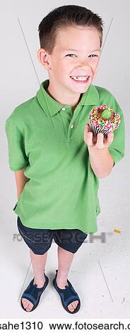 Little boy holding cupcake View Large Photo Image Stock Image - Little boy holding cupcake . Fotosearch