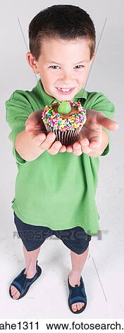 Little boy holding cupcake View Large Photo Image Stock Image - Little boy holding cupcake . Fotosearch
