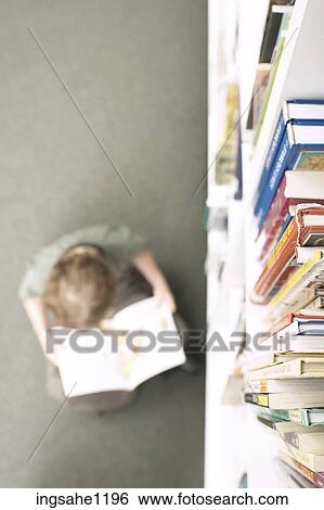 Little boy reading book beside library shelf 1 View Large Photo Image Stock Photograph - Little boy reading book beside library shelf 1. Fotosearch