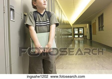 Little boy with school books leaning against lockers 3 View Large Photo Image Stock Image - Little boy with school books leaning against lockers 3. Fotosearch