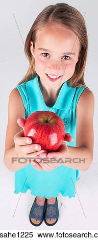Little girl holding apple View Large Photo Image Stock Photography - Little girl holding apple . Fotosearch