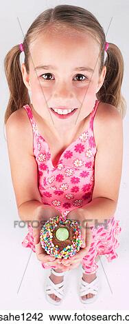 Stock Image - Little girl holding cupcake . Fotosearch