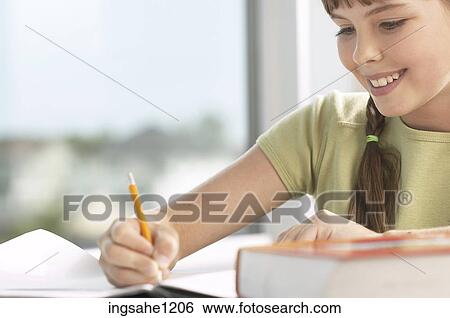 Little girl writing at her desk 1 View Large Photo Image Stock Photograph - Little girl writing at her desk 1. Fotosearch
